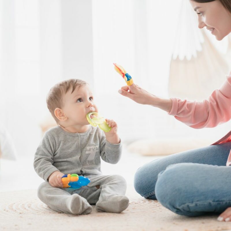 Happy mother nanny babysitter playing games with little small kid child toddler newborn baby infant, developing skills and imagination, learning educating son daughter before kindergarten. Motherhood